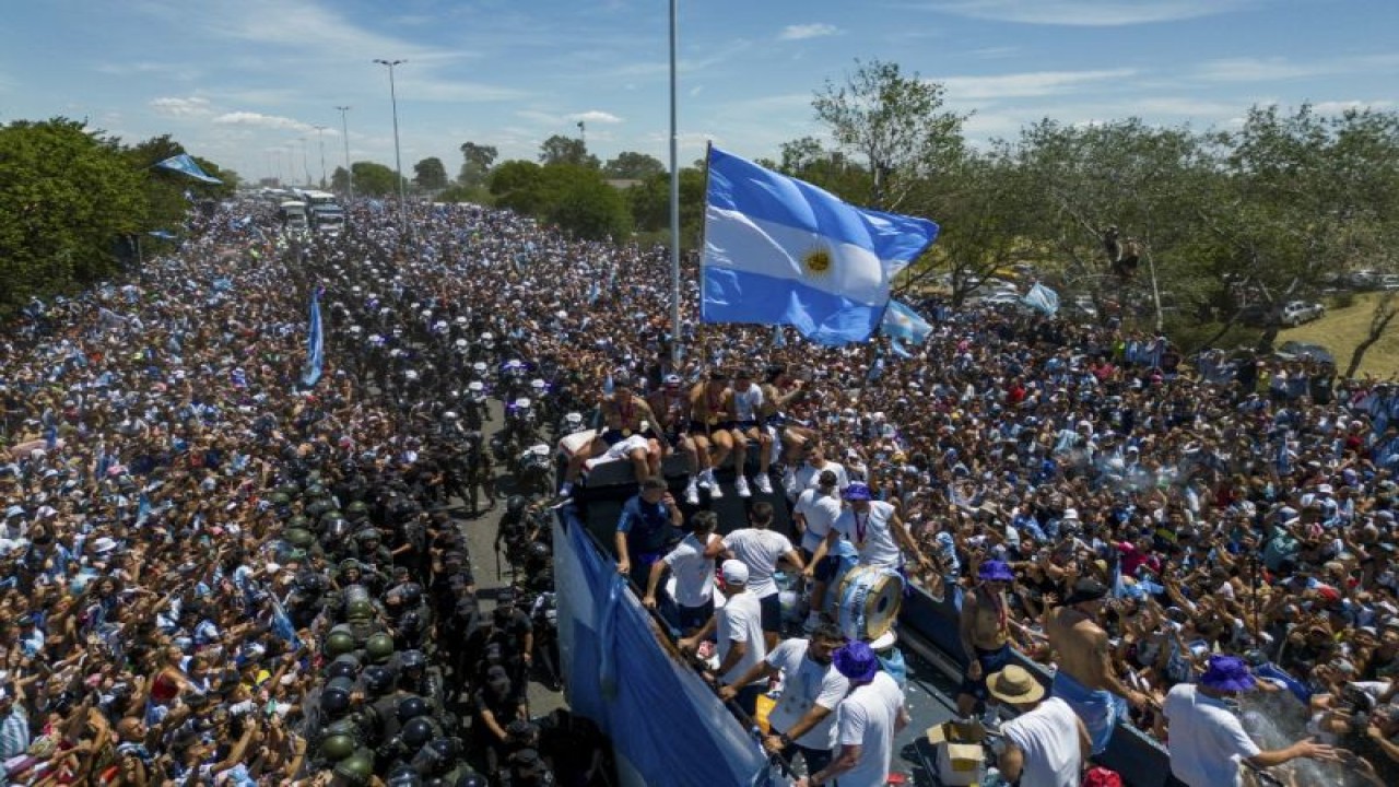 Para pemain Argentina berpawai menumpangi sebuah bus yang bertuliskan "Juara Dunia" bersama para suporter menyusuri pusat kota Buenos Aires pada 20 Desember 2022 setelah menjuarai Piala Dunia Qatar 2022. (Photo by Tomas CUESTA / AFP) (AFP/TOMAS CUESTA)