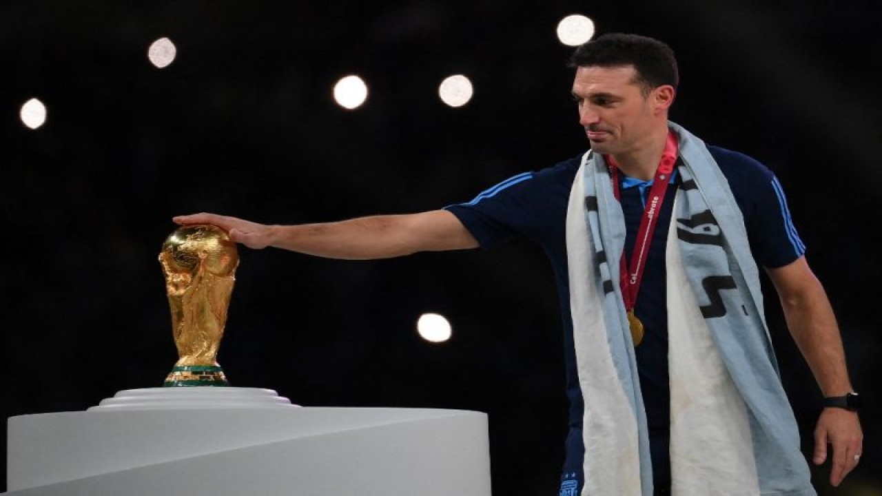 Pelatih Argentina Lionel Scaloni menyentuh trofi Piala Dunia setelah timnya memperoleh medali emas Piala Dunia Qatar 2022 usai final turnamen ini antara Argentina dan Prancis di Stadion Lusail, Doha, pada 18 Desember 2022. ANTARA/AFP/FRANCK FIFE