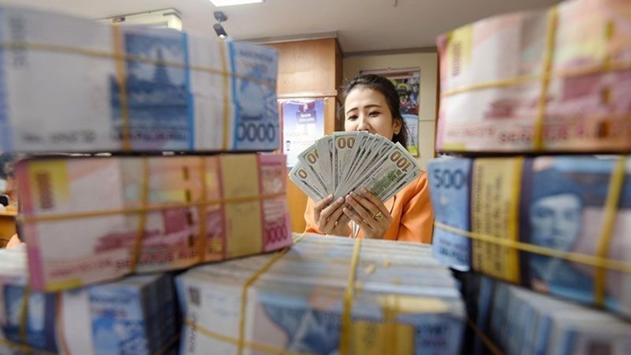 Arsip foto - Seorang wanita menghitung uang transaksi penukaran dolar AS dengan rupiah di Jakarta, Senin (3/8). (ANTARA FOTO/Akbar Nugroho Gumay/Rei/foc.)