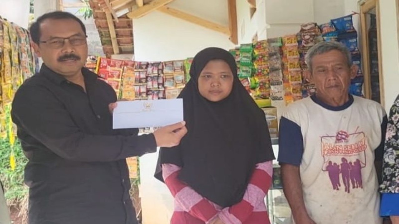 Kepala Dinas Pengendalian Penduduk, Keluarga Berencana, Pemberdayaan Perempuan, dan Perlindungan Anak (DPPKBPPPA) Garut, Yayan Waryana memberikan santunan secara simbolis kepada Rohimah asisten rumah tangga yang menjadi korban kekerasan majikannya di Kecamatan Limbangan, Kabupaten Garut, Jawa Barat, Kamis (15/12/2022). (FOTO ANTARA/HO-Diskominfo Garut)