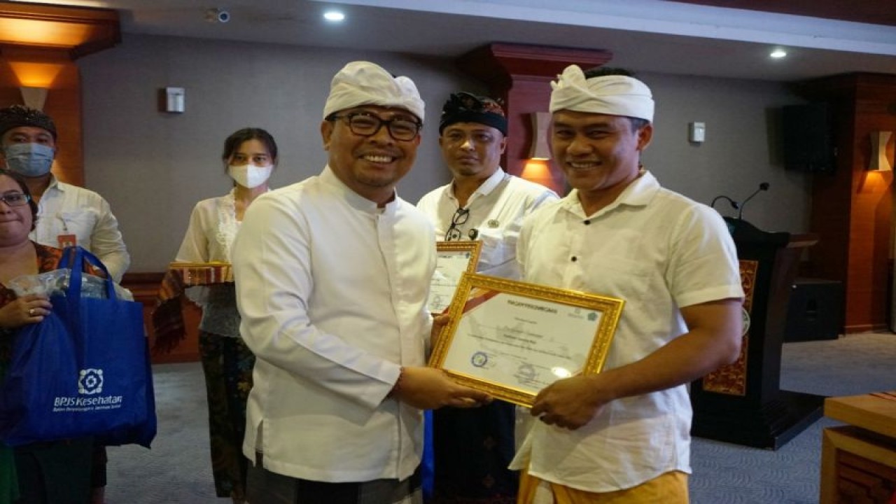 Wakil Wali Kota Denpasar I Kadek Agus Arya Wibawa saat menyerahkan piagam kepada empat fasilitator aktif atas kepengurusan data PPKS dan bantuan sosial pada tahun 2022 di Denpasar, Jumat (23/12/2022). ANTARA/HO-Pemkot Denpasar.