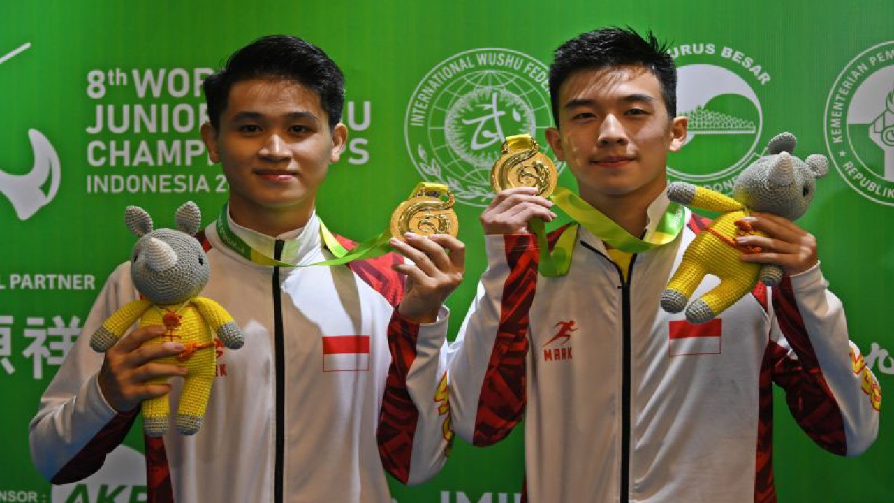 Atlet wushu Indonesia Josh Tiesto Tanto (kanan) dan Rainer Reinaldy Ferdiansyah (kiri) berpose dengan medali emas yang mereka raih dalam Kejuaraan Dunia Wushu Junior 2022 di ICE BSD, Kabupaten Tangerang, Banten, Selasa (6/12/2022). . ANTARA FOTO/Aditya Pradana Putra/rwa. (ANTARA FOTO/ADITYA PRADANA PUTRA)