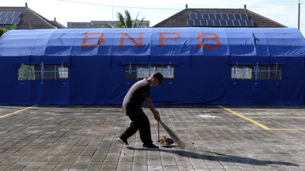 Petugas kebersihan menyapu di dekat tenda yang didirikan BPBD setempat di halaman RSUD Kabupaten Karangasem, Bali, Rabu (14/12/2022). Pemasangan dua tenda darurat tersebut untuk mengantisipasi gempa susulan menyusul terjadinya gempa bumi dengan magnitudo 5,2 yang mengguncang Kabupaten Karangasem, Bali, pada Selasa (13/12), pukul 18.38 WITA. ANTARA FOTO/Nyoman Hendra Wibowo/wsj.