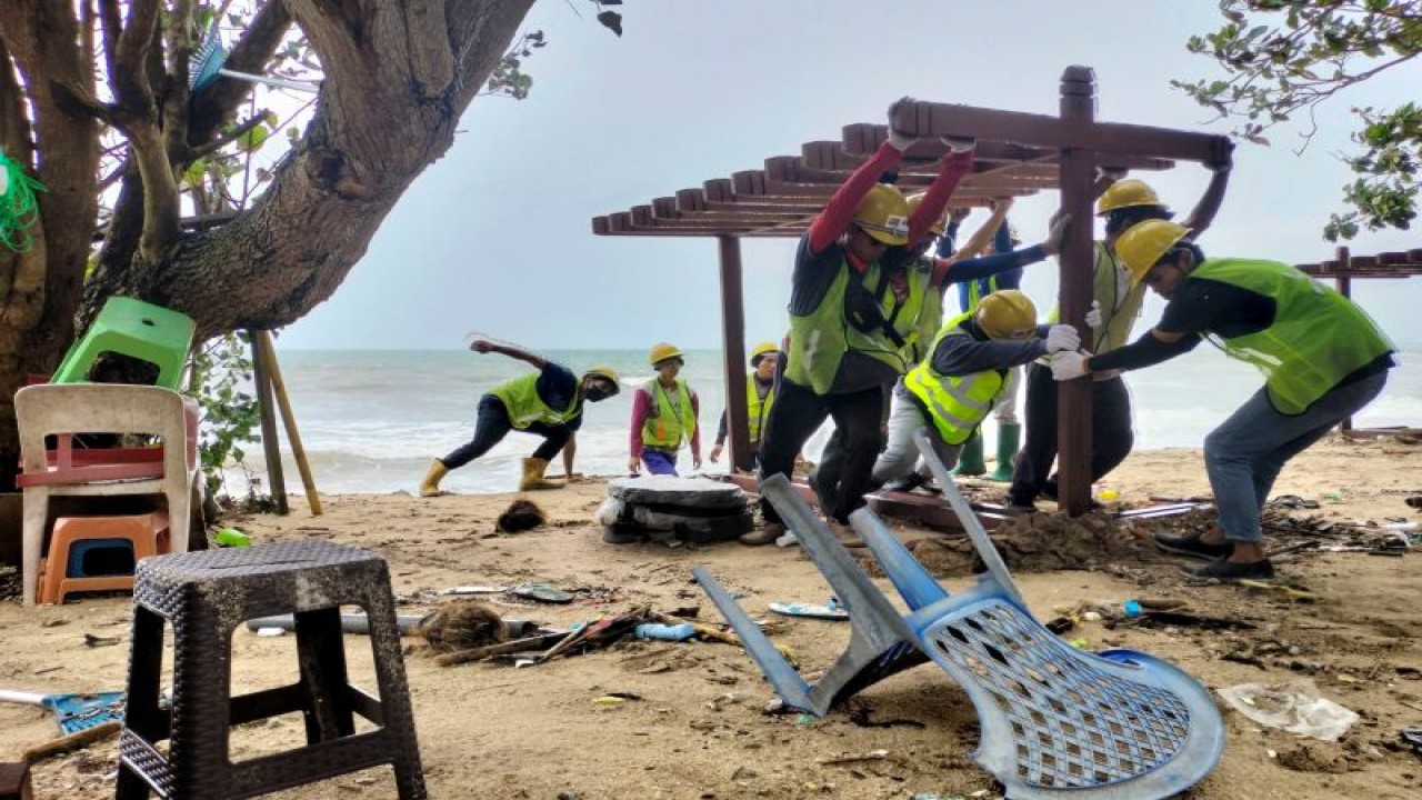 Sejumlah pekerja mengangkat tempat papan selancar yang sempat terseret ombak akibat gelombang tinggi di Pantai Kuta, Badung, Bali, Sabtu (24/12/2022). Hujan disertai angin kencang yang terjadi pada Jumat (23/12) malam tersebut merusak puluhan lapak dagang warga dan saat ini aktivitas berjualan di sepanjang pantai tersebut ditutup sementara menyusul situasi cuaca belum kondusif. ANTARA FOTO/Nyoman Hendra Wibowo/aww.