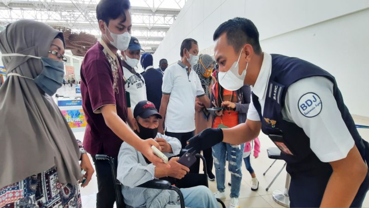 Petugas Bandara Internasional Syamsudin Noor memeriksa aplikasi PeduliLindungi bagi calon penumpang di area keberangkatan. (ANTARA/Firman)