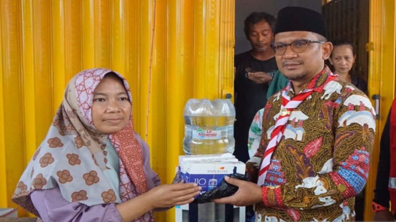 Wakil Bupati Garut, Jawa Barat, Helmi Budiman menyerahkan bantuan uang Rp 25 juta pada perwakilan warga korban gempa di Kampung Kadudampit, Desa Rancagoong, Kecamatan Cilaku, Cianjur, Rabu (14/12/2022).(ANTARA/Ahmad Fikri). (Ahmad Fikri)