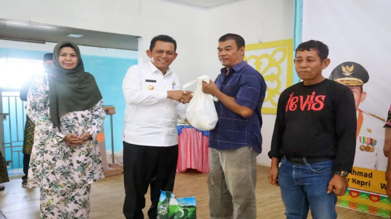 Gubernur Kepri Ansar Ahmad menyerahkan bantuan sembako kepada perwakilan warga di Gedung Nasional, Tanjung Uban, Bintan, Jumat (30/12/2022). (ANTARA/HO-Humas Pemprov Kepri)
