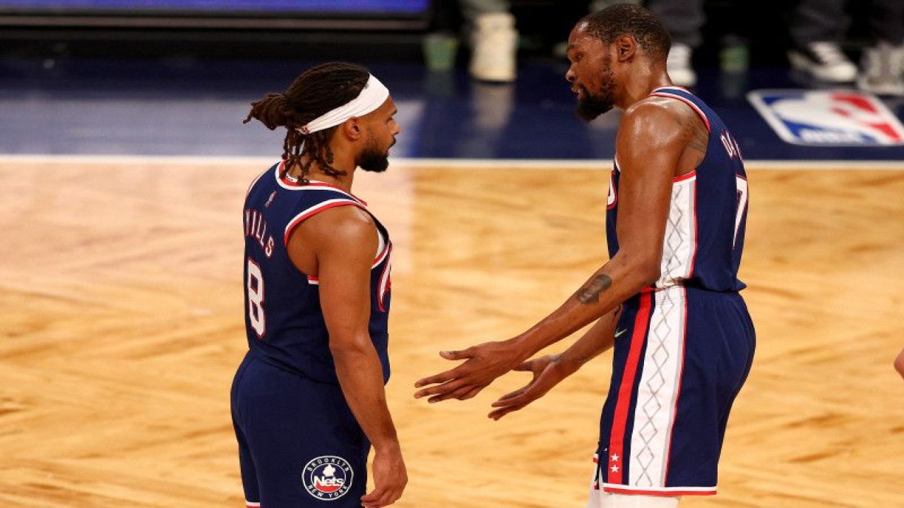 Arsip - Duo pebasket Brooklyn Nets Kevin Durant (Kanan) dan Patty Mills berbincang saat laga NBA kontra Boston Celtics di Barclays Center pada 25 April 2022 (Getty Images via AFP/ELSA)