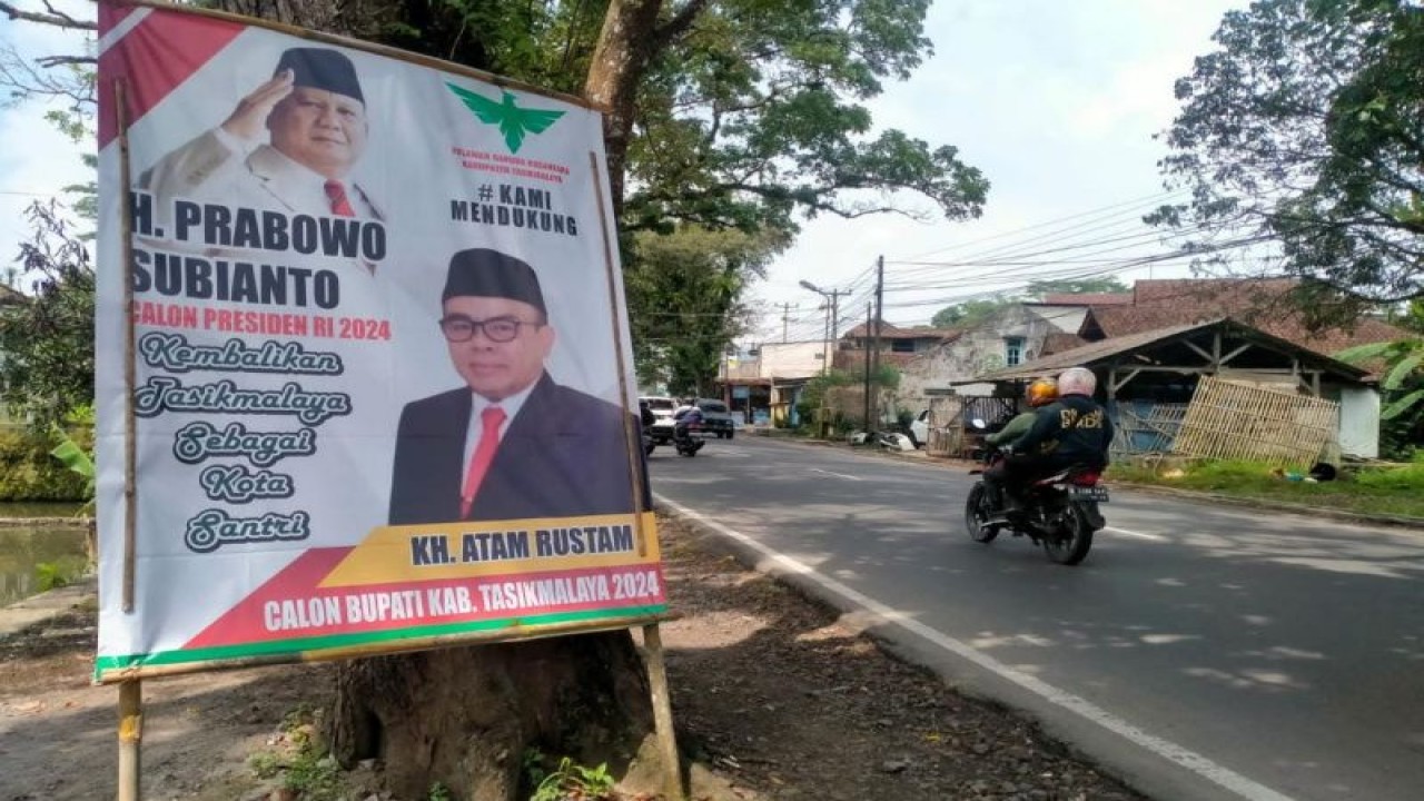 Pengendara melewati poster berupa dukungan pencalonan Bakal Calon Bupati Tasikmalaya tahun 2024 terhadap salah seorang warga yang statusnya masih sebagai Aparatur Sipil Negara yang dipasang di pinggir Jalan Singaparna, Kabupaten Tasikmalaya, Jawa Barat. (ANTARA/HO-Warga Tasikmalaya)