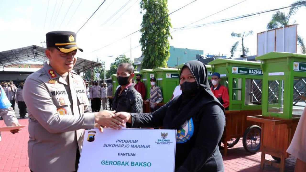 Kepala Polres Sukoharjo AKBP Wahyu Nugroho Setyawan secara simbolis menyerahkan bantuan gerobak bakso kepada seorang pedagang di Markas Polres Sukoharjo, Rabu (21/12/2022). (ANTARA/Bambang Dwi Marwoto)