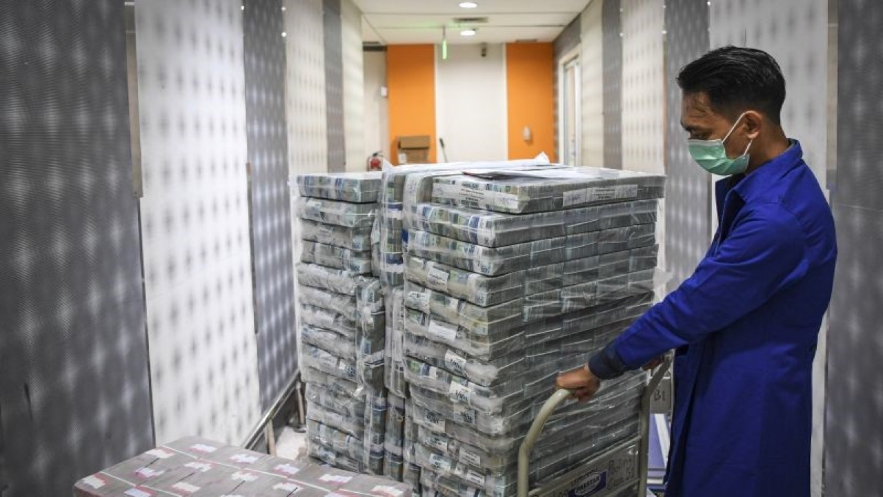 Ilustrasi: Petugas menarik tumpukan uang tunai sebelum didistribusikan melalui kantor cabang dan mesin ATM di Pooling Cash Plaza Mandiri, Jakarta. ANTARA FOTO/M Risyal Hidayat/foc. (ANTARA FOTO/M RISYAL HIDAYAT)