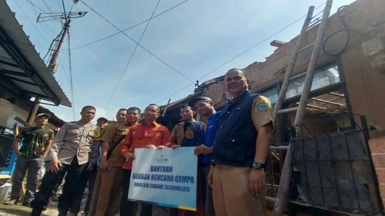 Perwakilan dari Pemkot Tasikmalaya dan BJB menyerahkan bantuan untuk warga yang rumahnya rusak akibat guncangan gempa bumi di Tuguraja, Kecamatan Cihideung, Kota Tasikmalaya, Jawa Barat, Senin (5/12/2022). (FOTO ANTARA/HO-BJB)