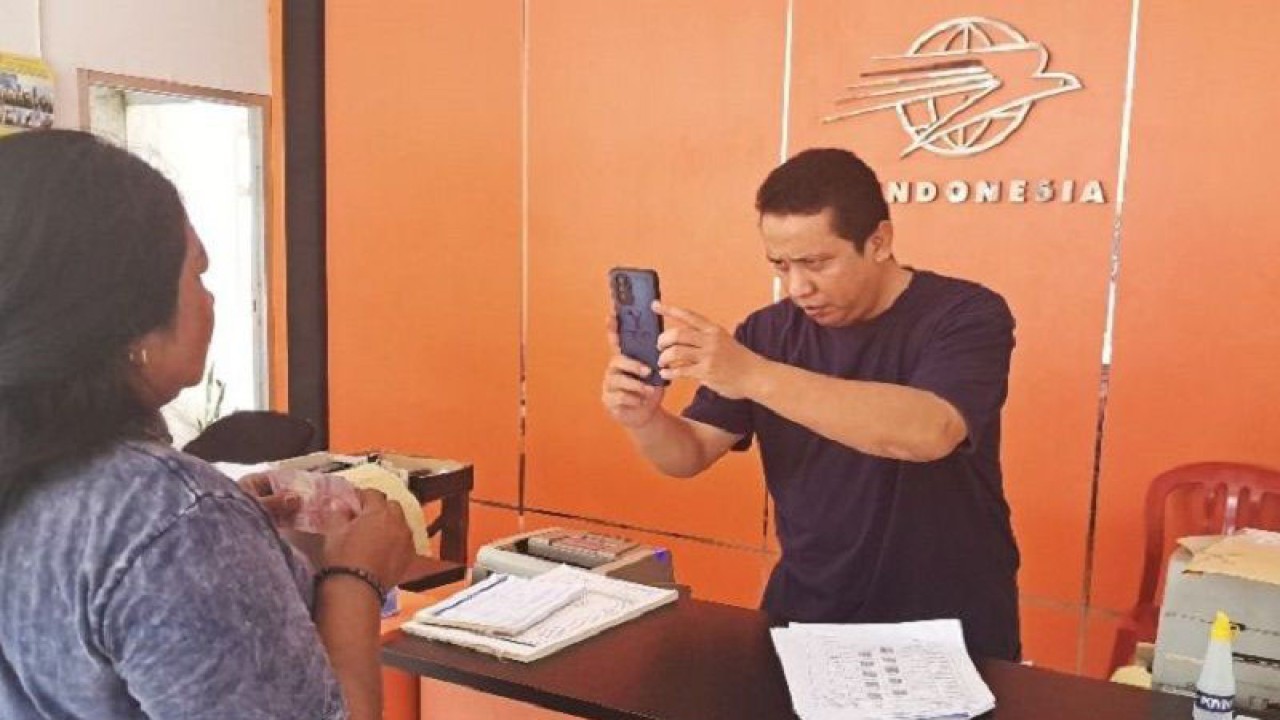 Pejabat Sementara Kepala Kantor Pos Kuala Kurun Jembi saat proses penyaluran BLT BBM kepada salah satu KPM di Kecamatan Kurun. (ANTARA/Chandra)