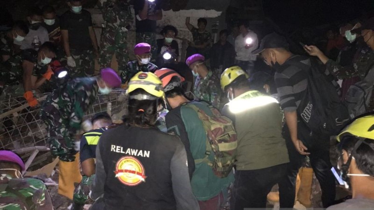 Tim SAR gabungan berhasil menemukan jasad anak laki-laki 11 tahun dari balik puing rumah yang ambruk di Desa Cibulakan, Kecamatan Cugenang, Cianjur, Jawa Barat, Minggu (11/12/2022). (ANTARA/Ahmad Fikri)