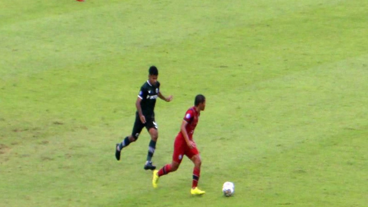 Pemain Arema FC Adam Alis ( kostum merah merah) saat membawa bola dijaga ketat pemain Persikabo, Syahrul Lasinari, ( kostum hijau hitam) dalam pertandingan Liga 1 2022 di Stadion Manahan Solo, Rabu (14/12/2022). ANTARA/Bambang Dwi Marwoto.