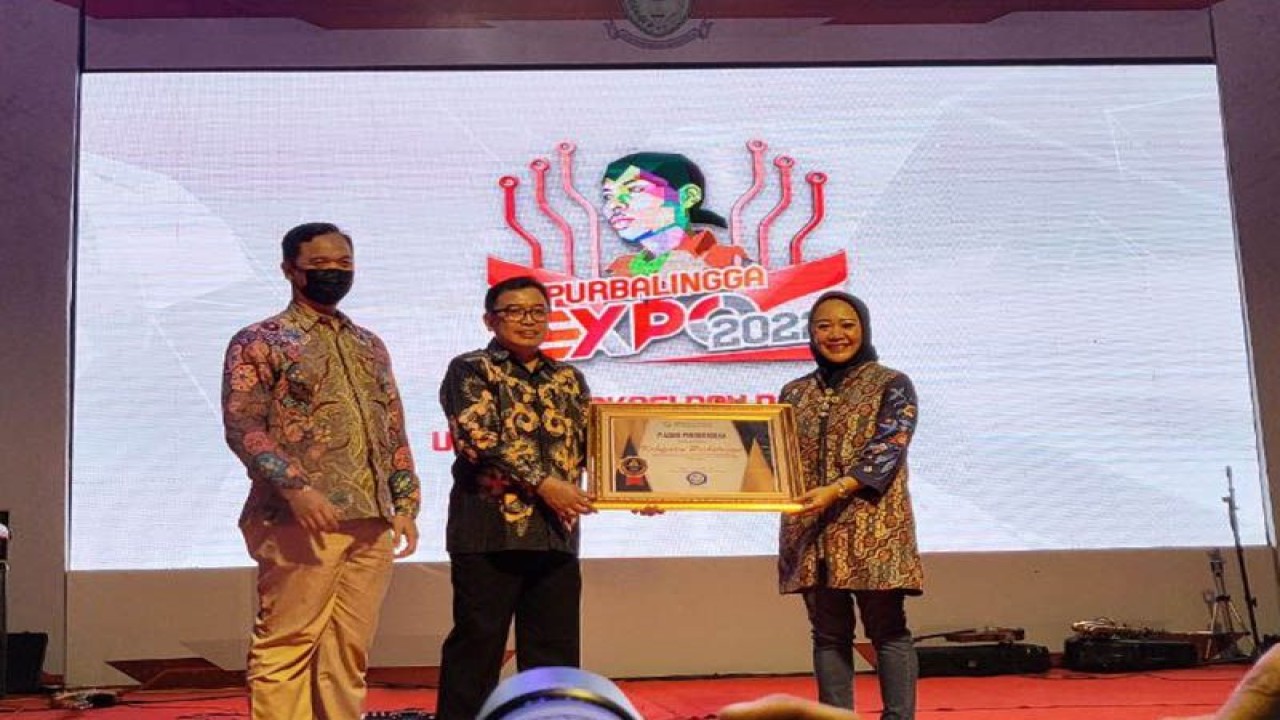 Asisten Deputi Perencanaan, Iuran, dan Keuangan BPJS Kesehatan Kedeputian Wilayah Jawa Tengah dan Daerah Istimewa Yogyakarta Markus Susilo (dua dari kiri) menyerahkan piagam penghargaan kepada Bupati Purbalingga Dyah Hayuning Pratiwi atas pencapaian universal health coverage (UHC) di Purbalingga, Kamis (15/12/2022) malam. FOTO ANTARA/HO-BPJS Kesehatan