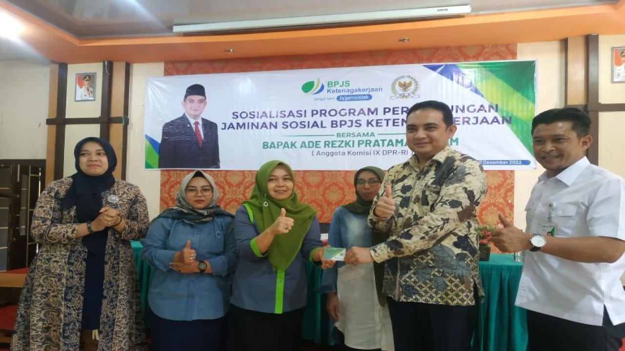 Legislator Ade Rezki Pratama saat menyerahkan secara simbolis kartu BPJS Ketenagakerjaan yang didaftarkan dan iuran gratis selama tiga bulan. ANTARA/Akmal Saputra