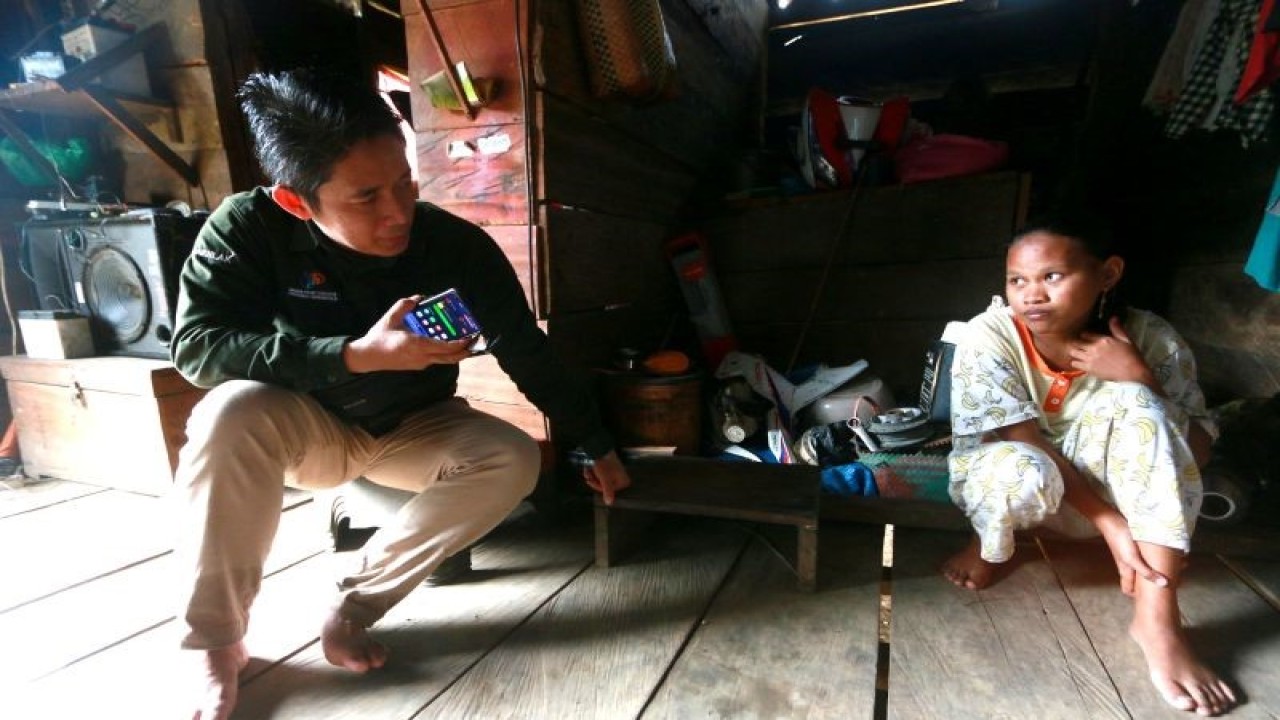 Statistisi Ahli Madya Badan Pusat Statistik (BPS) Provinsi Gorontalo, Prasaja Arifiyanto (kiri) berbincang dengan menggunakan penerjemah bersama warga di dusun terpencil Tumba di Kabupaten Gorontalo, Gorontalo, Selasa (27/12/2022). ANTARA/Adiwinata Solihin