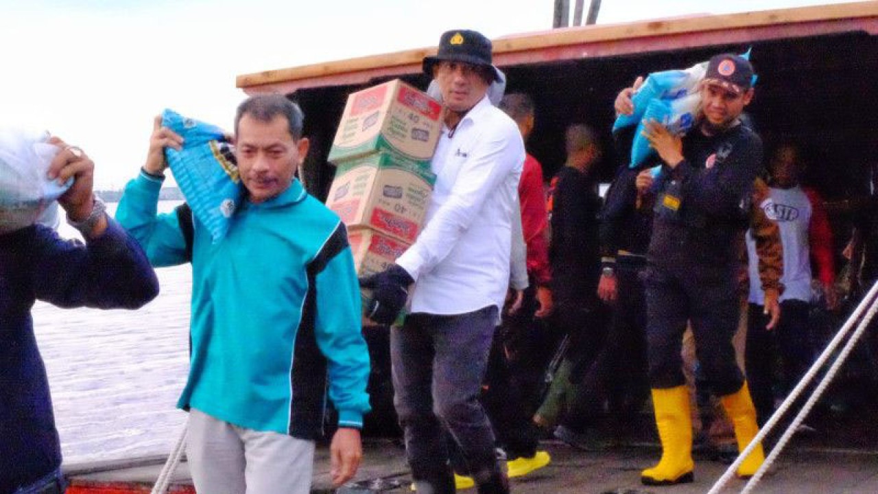 Arsip Foto. Bupati Kepulauan Meranti Muhammad Adil membantu petugas mengangkut bantuan untuk warga yang terdampak banjir di Kecamatan Rangsang Barat pada Jumat (16/12/2022). (ANTARA/Rahmat Santoso)