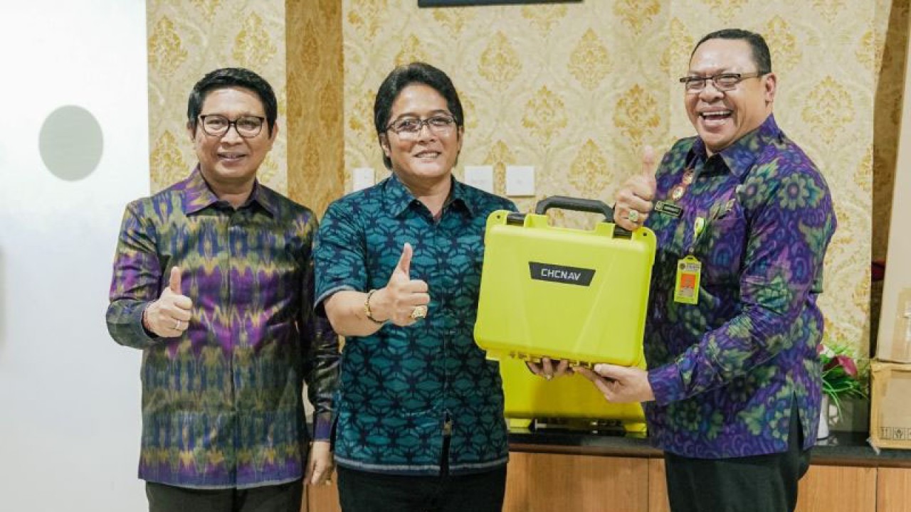 Bupati Badung I Nyoman Giri Prasta (tengah) didampingi Sekda Badung I Wayan Adi Arnawa (kiri) menyerahkan peralatan pengukuran tanah kepada Kepala Kantor BPN Badung Heryanto. ANTARA/HO-Pemkab Badung.