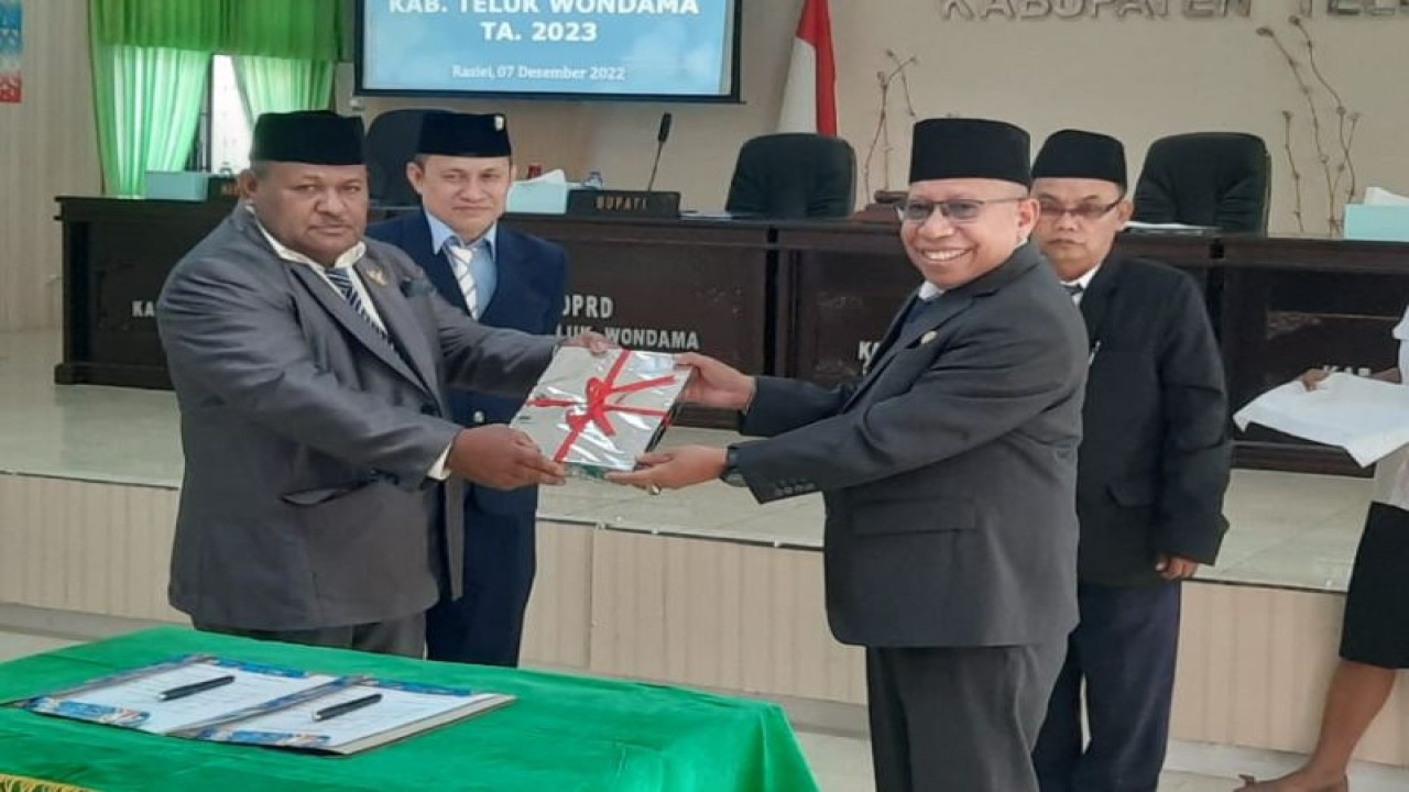 Ketua DPRD Teluk Wondama Herman Sawasemariai menyerahkan dokumen Perda APBD 2023 yang telah ditentukan kepada Bupati Teluk Wondama Hendrik Mambor. (ANTARA/HO-Zack Tonu B)