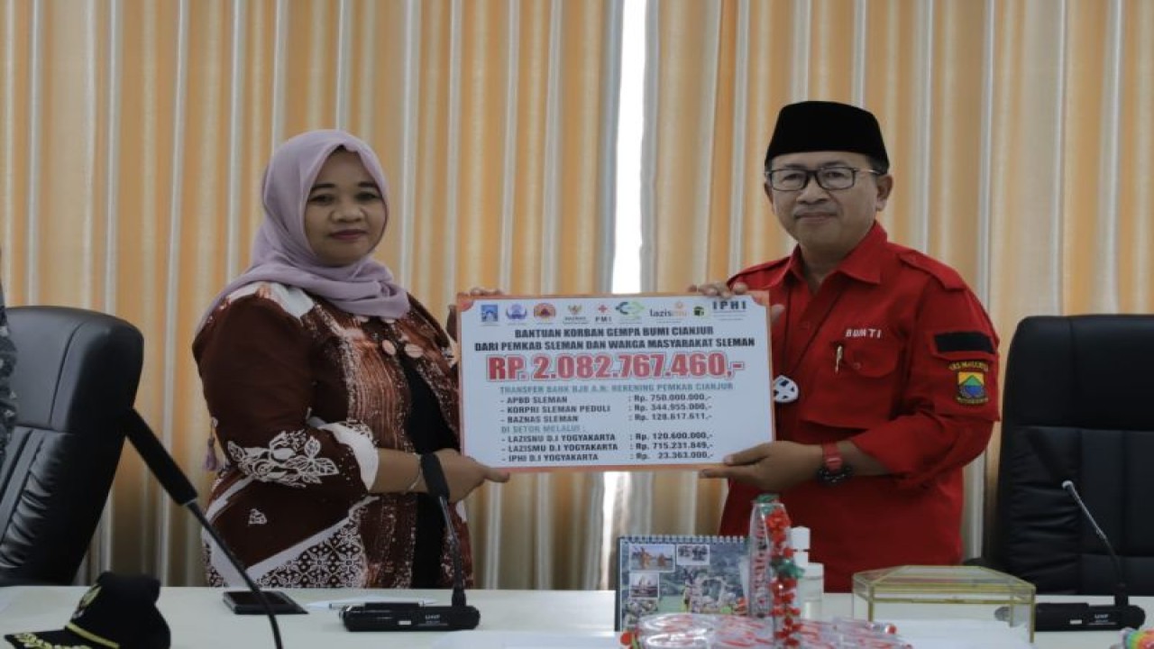 Bupati Sleman Kustini Sri Purnomo menyerahkan bantuan uang dari "Sleman Peduli Gempa Cianjur" senilai Rp 2 miliar lebih kepada Bupati Cianjur Herman Suherman di Kantor Bupati Cianjur, Jawa Barat, Selasa (20/12/22). ANTARA/HO-Bagian Prokopim Setda Sleman