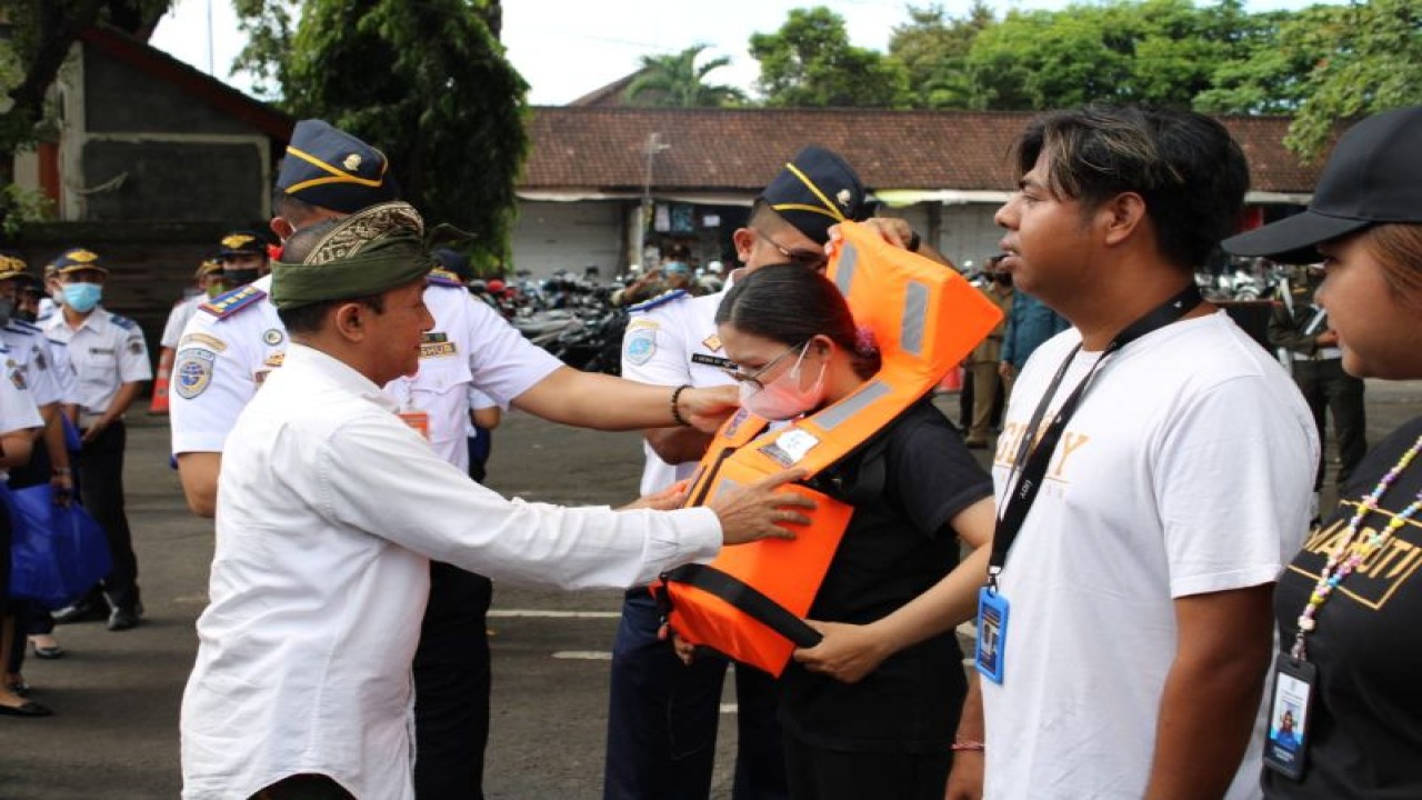 Asisten Administrasi Pembangunan Setda Kota Denpasar AA Gde Risnawan saat mengenakan alat bantu pengaman berupa life jacket  kepada perwakilan Asosiasi Fast Boat Sanur  dalam acara pembukaan posko terpadu jelang Natal dan Tahun Baru 2023 di Denpasar, Senin (19/12/2022). ANTARA/HO-Pemkot Denpasar.