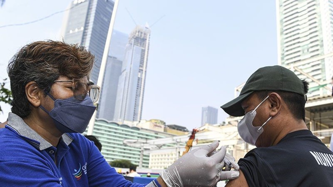 Arsip Foto - Petugas kesehatan menyuntikkan vaksin COVID-19 saat "Car Free Day" atau Hari Bebas Kendaraan Bermotor di kawasan MH Thamrin, Jakarta, Minggu (31/7/2022). ANTARA FOTO/M Risyal Hidayat/foc/pri.