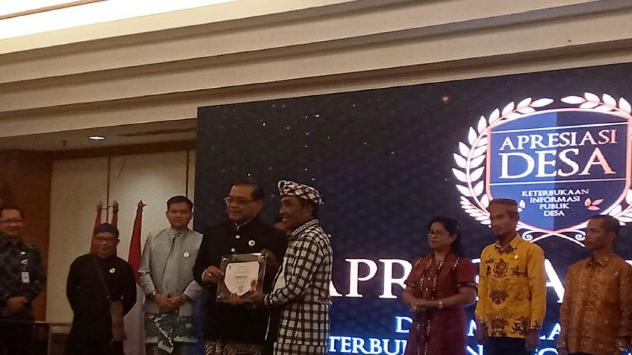 Ketua KI Pusat Donny Yoesgiantoro menyerahkan piagam penghargaan kepada Kepala Desa Duda Timur, Kabupaten Karangasem, Provinsi Bali, pada acara Apresiasi Desa dalam Pelaksanaan Keterbukaan Informasi Publik Desa di Hotel Grand Sahid Jaya, Jakarta, Kamis (8/12/2022). ANTARA/Tri Meilani Ameliya.
