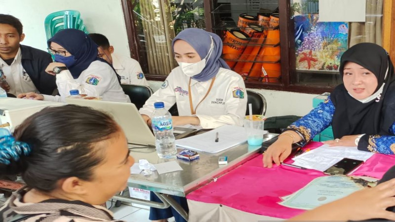 Kepala Sektor Dinas Dukcapil Kecamatan Tebet Lidya Oktavia (kanan) dan tim melayani warga terdampak kebakaran membuat dokumen kependudukan yang hilang dalam kebakaran di Sekretariat RW 01 Kelurahan Manggarai, Jakarta, Senin (19/12/2022). (ANTARA/Yoanita HD)