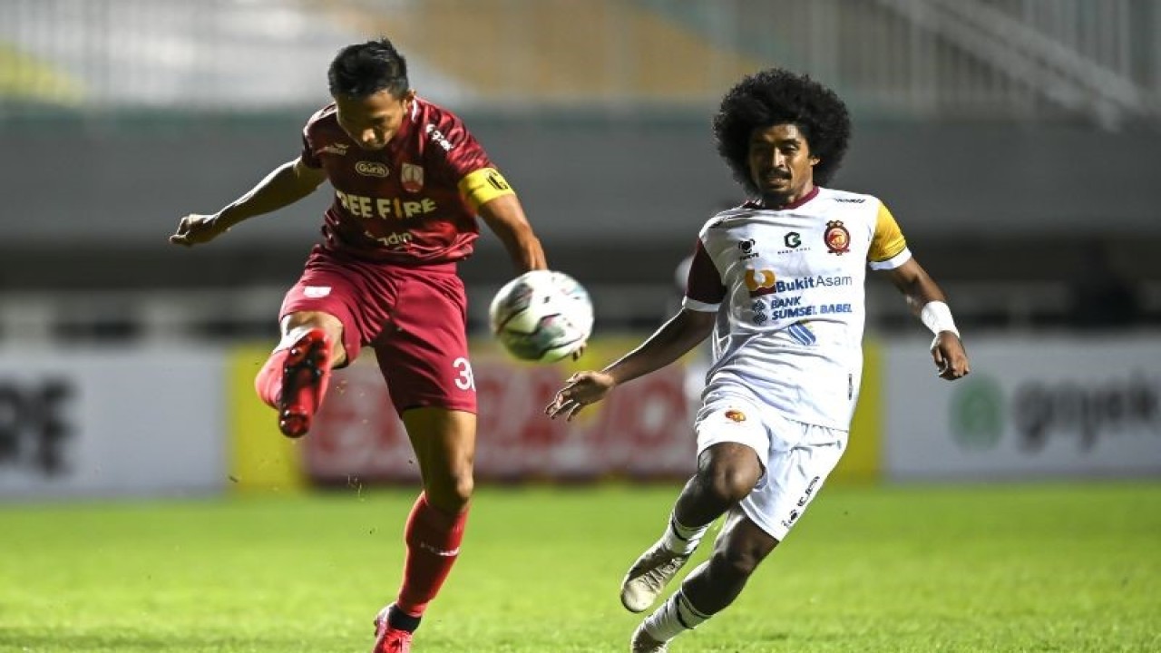 Foto arsip - Pesepak bola Persis Solo Eky Taufik (kiri) menendang bola dari pesepak bola Sriwijaya FC Sunawan Rusni (kanan) dalam lanjutan babak delapan besar Liga 2 di Stadion Pakansari, Kabupaten Bogor, Jawa Barat, Minggu (19/12/2021). . ANTARA FOTO/M Risyal Hidayat/aww (ANTARA FOTO/M RISYAL HIDAYAT)