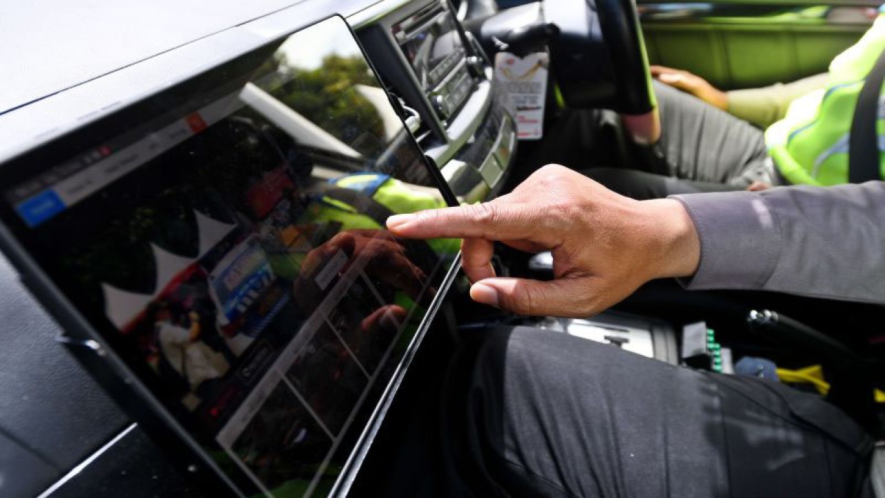 Polisi menunjukkan cara kerja perangkat sistem tilang elektronik (ETLE) Mobile yang diluncurkan di Mapolda Metro Jaya, Jakarta, Selasa (13/12/2022). ANTARA FOTO/Aditya Pradana Putra/hp.