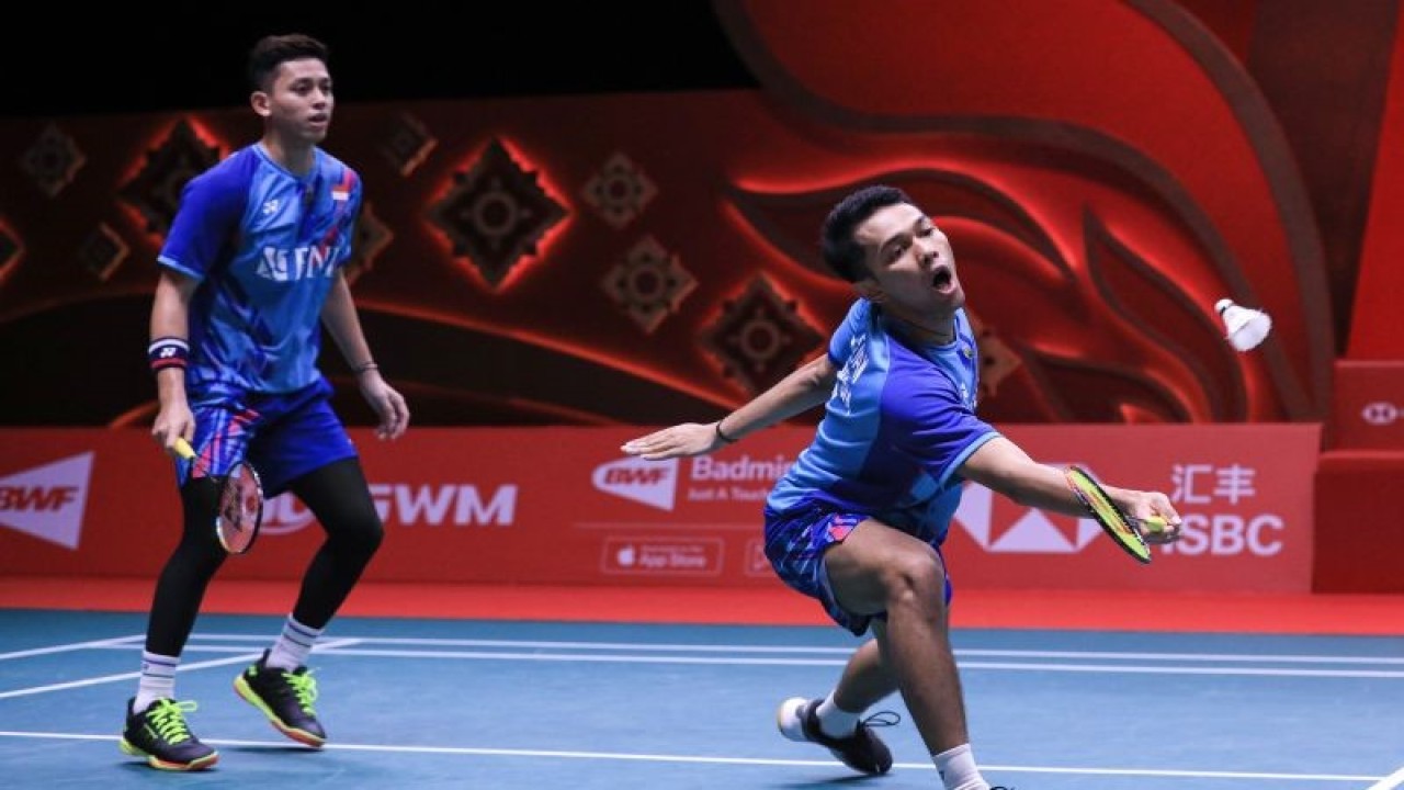 Pebulutangkis ganda putra Indonesia Fajar Alfian (kanan) dan Muhammad Rian Ardianto (kiri) memukul kok ke arah lawannya asal Jepang Takuro Hoki dan Yugo Kobayashi dalam pertandingan kedua fase grup A BWF World Tour Finals 2022 di Nimibutr Arena, Bangkok, Thailand, Kamis (8/12/2022). ANTARA FOTO/Handout/Humas PBSI/app/hp.
