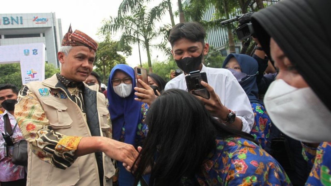Gubernur Jawa Tengah Ganjar Pranowo (kiri) menyapa warga saat menghadiri Road to Hakordia (Hari Antikorupsi Sedunia) di Alun-Alun Surabaya, Jawa Timur, Kamis (1/12/2022). . ANTARA FOTO/Didik Suhartono/rwa. b