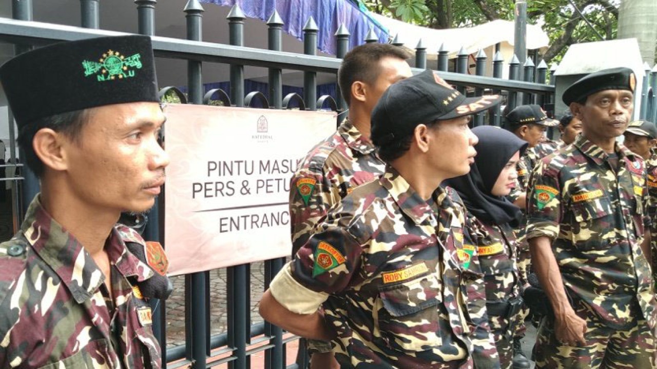 Sejumlah anggota Banser Pemuda Ansor berjaga di salah satu pintu masuk Gereja Katedral dalam rangka membantu pengamanan ibadah Jumat Agung sebagai rangkain ibadah Paskah di Jakarta, Jumat (19/4/2019). ANTARA/Aditya Ramadhan  KOMENTAR
