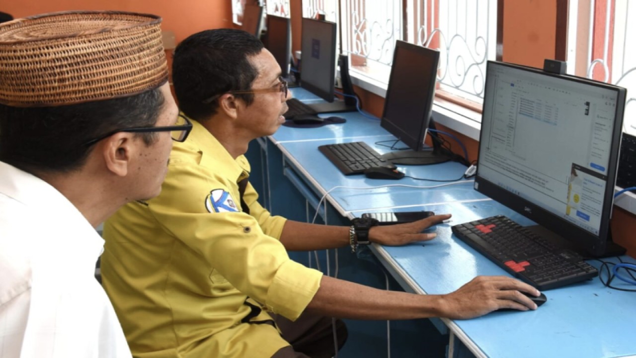 Pegawai Diskominfotik Provinsi Gorontalo membantu kepala sekolah memasukkan data pribadi untuk penerbitan Sertifikat Elektronik di laboratorium komputer SMK Negeri 3 Kota Gorontalo, Rabu (21/12/2022). (FOTO ANTARA/HO-kominfo)