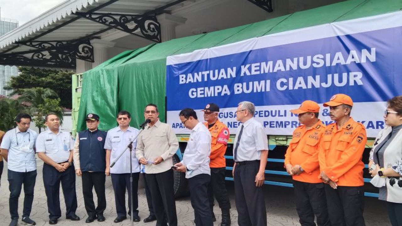 Penjabat Gubernur DKI Heru Budi Hartono (enam dari kanan) memberikan keterangan pers saat penyerahan bantuan kepada korban gempa Cianjur di Balai Kota Jakarta, Rabu (14/12/2022). ANTARA/Dewa Ketut Sudiarta Wiguna