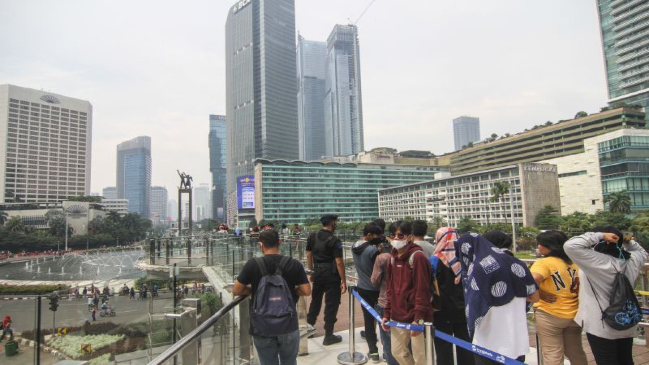 Sejumlah warga berfoto di anjungan Halte TransJakarta Bundaran HI saat uji coba anjungan itu di kawasan Bundaran Hotel Indonesia, Jakarta, Minggu (9/10/2022). Anjungan yang berada di lantai dua Halte Transjakarta Bundaran HI ini dapat menampung 20 orang dan menjadi spot foto baru dengan latar belakang Patung Selamat Datang dan air mancur Bundaran HI. ANTARA FOTO/Asprilla Dwi Adha/foc.