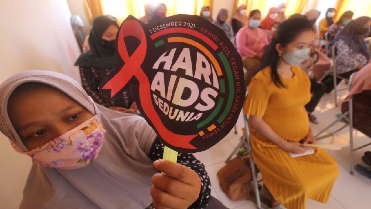 Ilustrasi - Seorang ibu hamil memperlihatkan kipas bertuliskan Hari AIDS Sedunia saat antre tes HIV di Puskesmas Semen, Kediri, Jawa Timur, Kamis (2/12/2021). ANTARA FOTO/Prasetia Fauzani/hp.