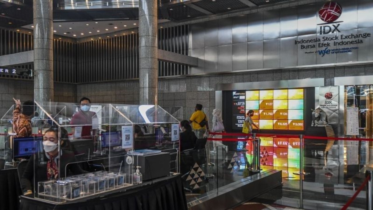 Karyawan melintas di samping layar elektronik yang menunjukkan pergerakan Indeks Harga Saham Gabungan (IHSG) di Bursa Efek Indonesia, Jakarta, Jumat (9/9/2022). ANTARA FOTO/Galih Pradipta/aww.