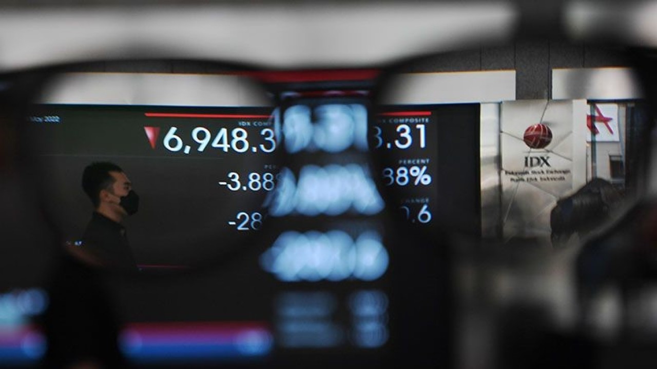 Pekerja melintas di depan layar yang menampilkan pergerakan Indeks Harga Saham Gabungan (IHSG) di Bursa Efek Indonesia, Jakarta, Senin (9/5/2022). ANTARA FOTO/Hafidz Mubarak A/pras/pri.