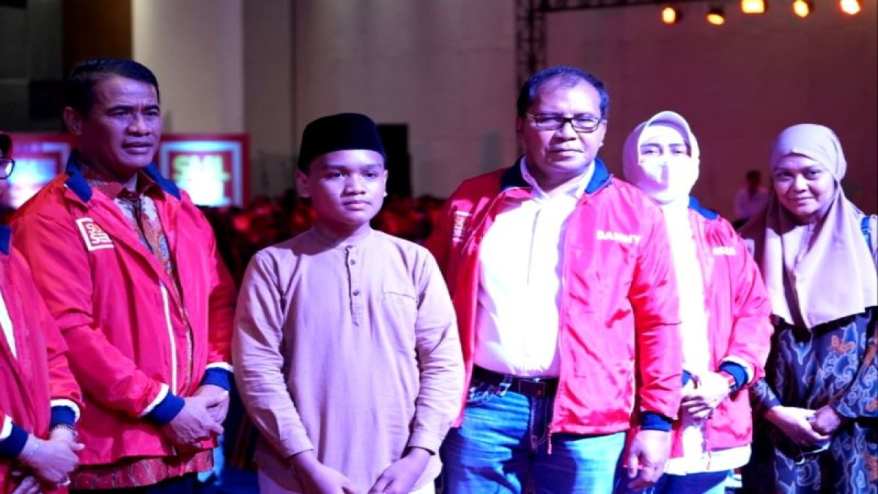 Ketua Umum IKA Unhas Andi Sudirman Sulaiman (kiri) bersama Ketua IKA Unhas wilayah Sulsel Moh Ramdhan Pomanto (tiga kanan) berfoto bersama anak korban Muhammad Alif Saputra Haswan (dua kiri) usai pemberian beasiswa di sela pelantikan pengurus IKA Unhas Sulsel di hotel Four Poin by Sheraton Makassar, Sulawesi Selatan, Senin (19/12/2022) malam.