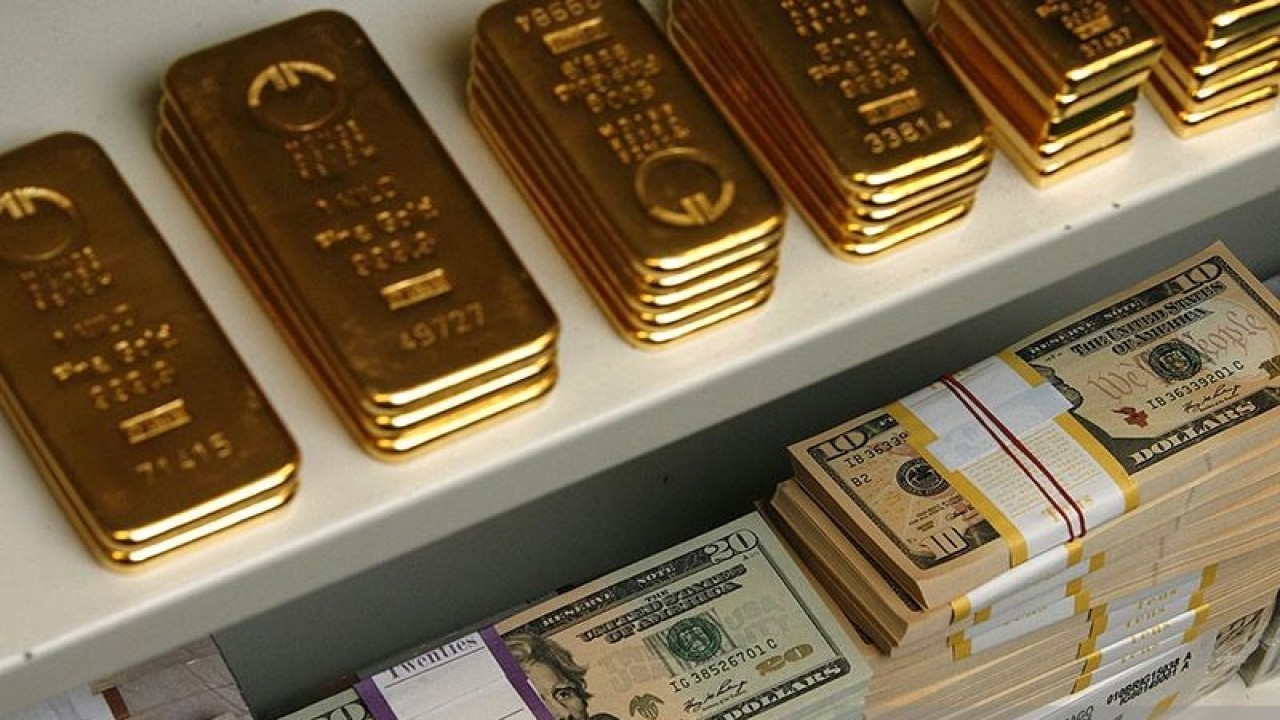 Ilustrasi - Emas batangan dan uang kertas dolar AS dalam brankas. ANTARA/REUTERS/Heinz-Peter Bader/aa.