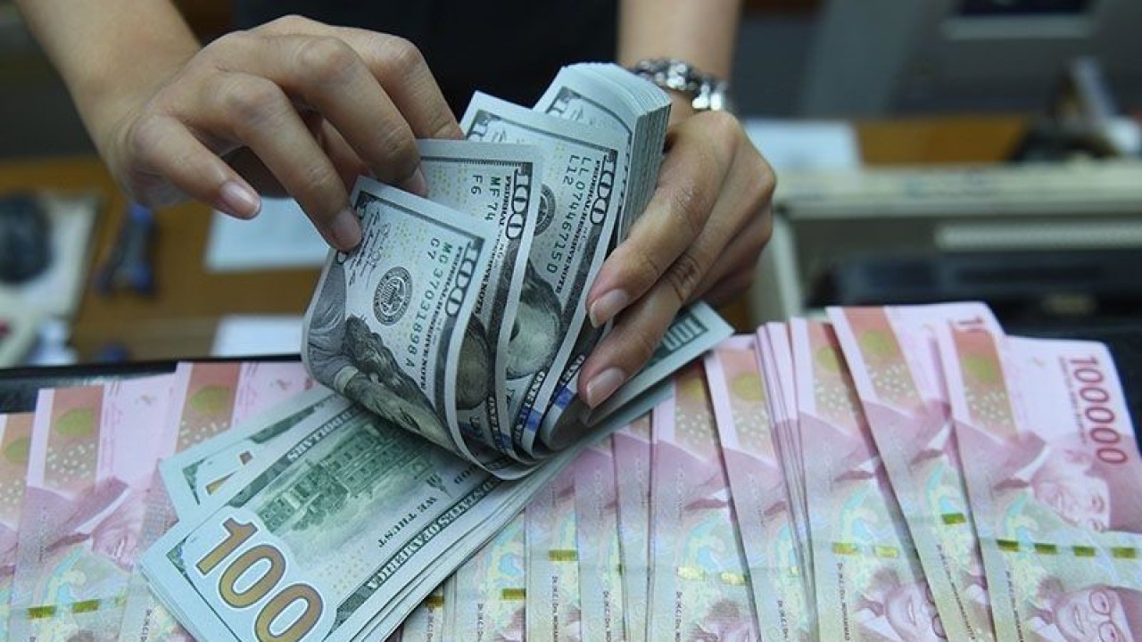 Ilustrasi: Pekerja menghitung uang dolar Amerika Serikat dan rupiah di sebuah tempat penukaran uang di Jakarta. (ANTARA FOTO/Akbar Nugroho Gumay/wsj/pri.)
