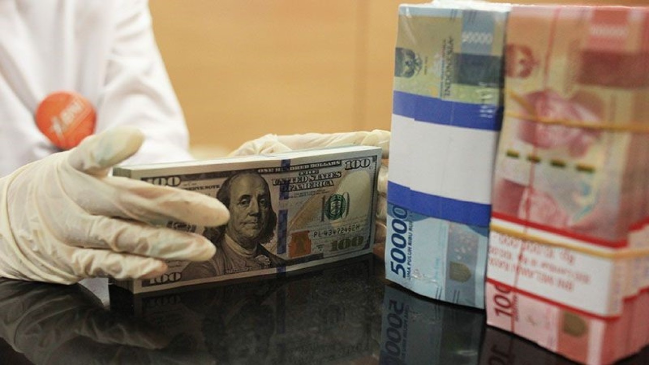 Ilustrasi: Petugas menghitung uang dolar AS dan uang rupiah di salah satu kantor cabang bank di Jakarta. ANTARA FOTO/Reno Esnir/foc. (ANTARA FOTO/RENO ESNIR)