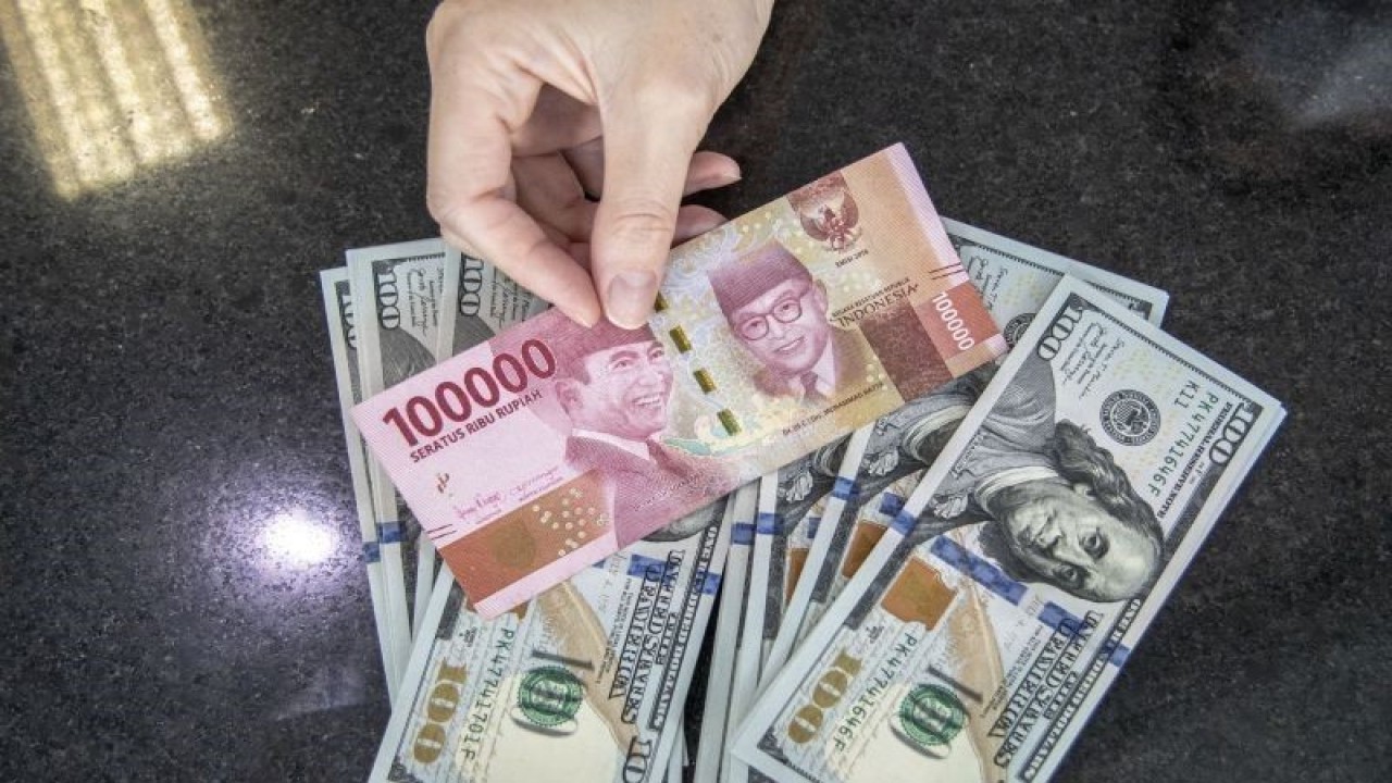 Ilustrasi: Petugas menghitung uang dolar AS dan uang rupiah di salah satu kantor cabang sebuah bank di Jakarta. (ANTARA FOTO/Reno Esnir/foc.)