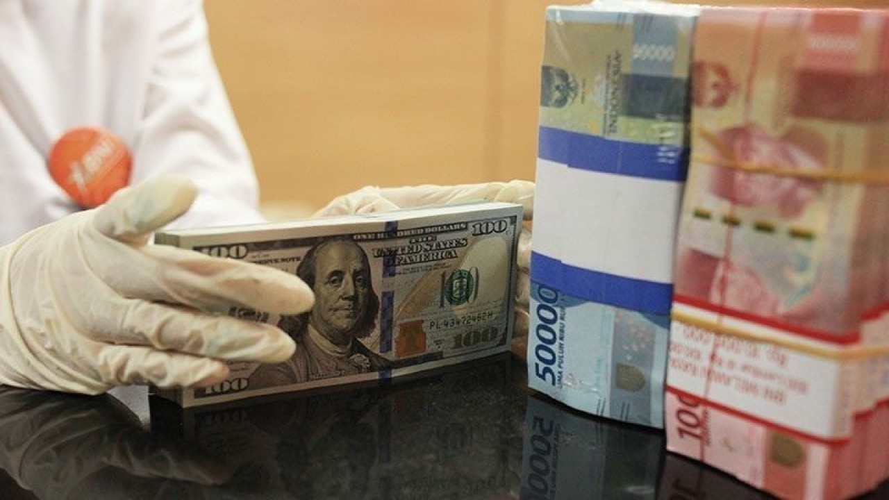 Ilustrasi - Petugas menghitung uang dolar AS dan uang rupiah di salah satu kantor cabang sebuah bank di Jakarta. ANTARA FOTO/Reno Esnir/foc.