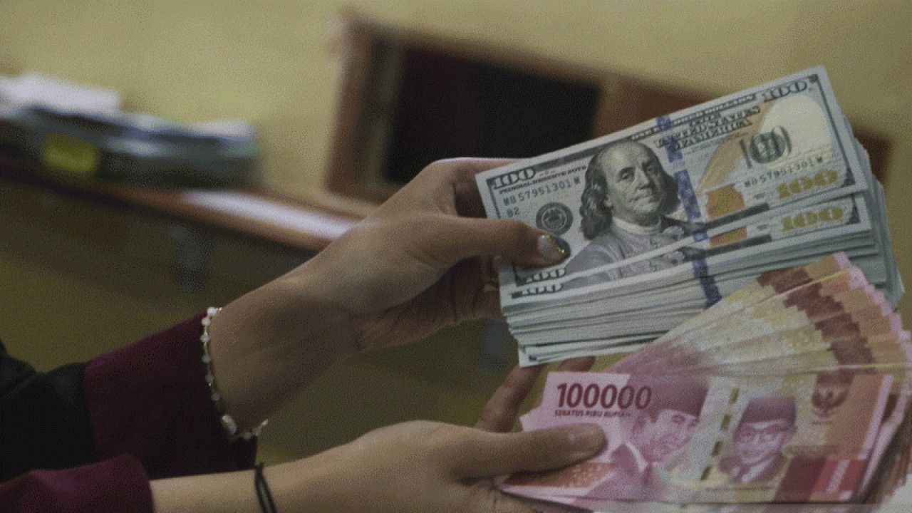 Ilustrasi: Petugas menunjukkan uang pecahan Rp100.000 dan 100 dolar AS di jasa penukaran uang asing di Jakarta. ANTARA FOTO/Rivan Awal Lingga/rwa.