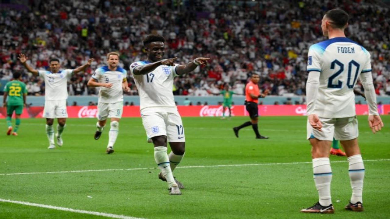 Pemain Inggris Bukayo Saka merayakan gol bersama rekannya Phil Foden dalam laga 16 besar Piala Dunai 2022 antara Inggris dan Senegal di Stadion Al-Bayt, Qatar, 4 Desember 2022. (AFP/PAUL ELLIS)