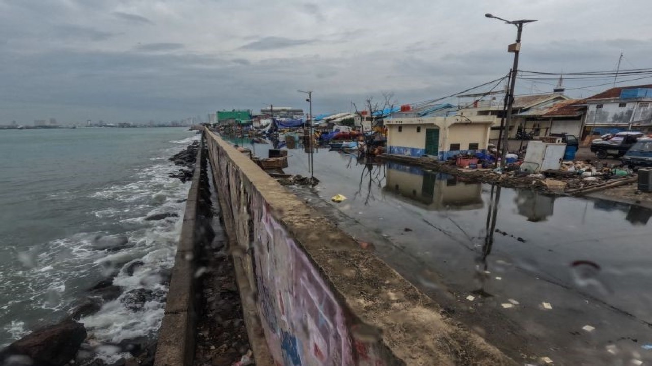 Suasana jalan yang terendam limpasan air laut ke daratan atau rob di Pelabuhan Muara Baru Jakarta, Rabu (28-12-2022). BMKG memprediksi pesisir di 21 daerah Indonesia terancam banjir rob hingga awal Januari 2023 akibat peningkatan ketinggian pasang air laut. ANTARA FOTO/Wahyu Putro A./foc.
